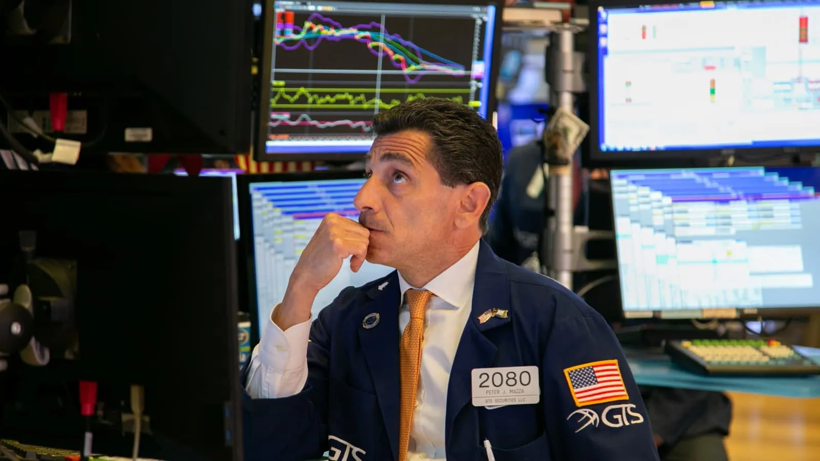 An image of a person on the nyse trading floor looking at stocks.